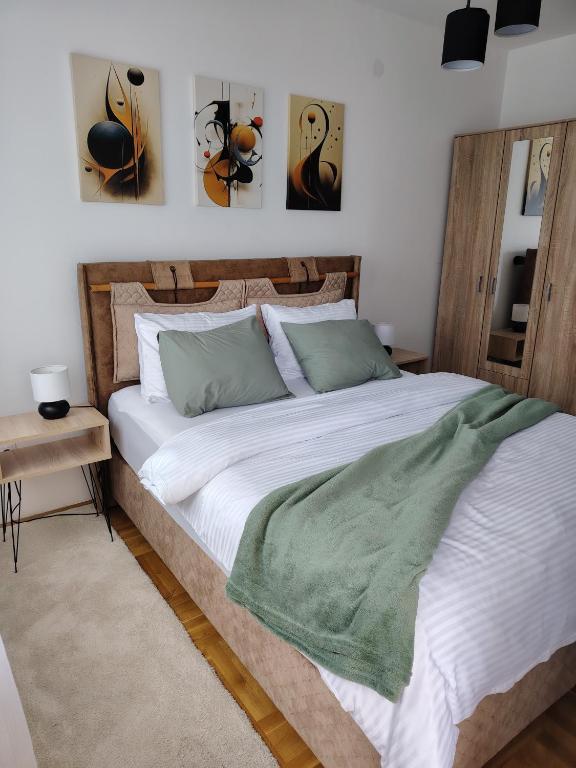 a bedroom with a large bed with green pillows at Apartman Fenix in Pirot