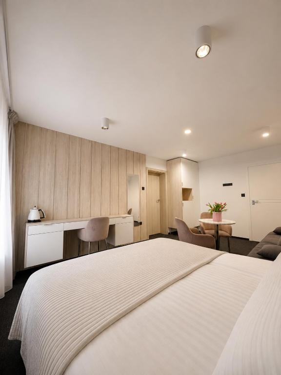 a hotel room with a large white bed and a kitchen at Villa Viola in Mielno
