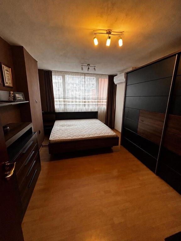 a small bedroom with a bed and a window at Голям двустаен апартамент in Burgas