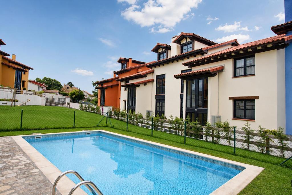 a swimming pool in front of a house at Apartamento La Castañera in Colombres