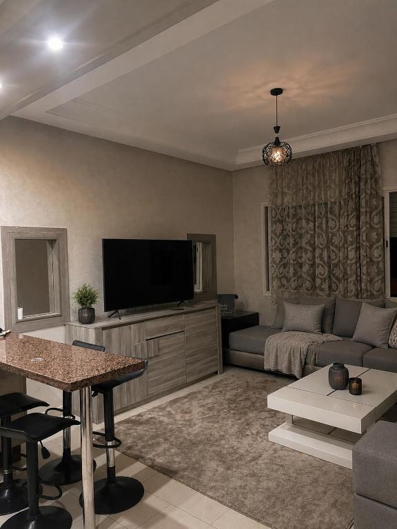 a living room with a couch and a flat screen tv at Parc app in Mohammedia