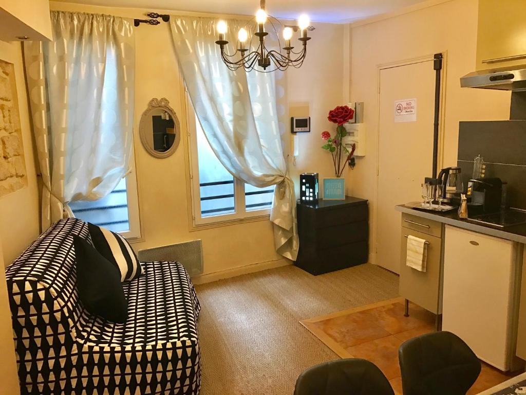 een woonkamer met een bank en een raam bij Appartement Luxembourg-proche St Germain des prés in Parijs