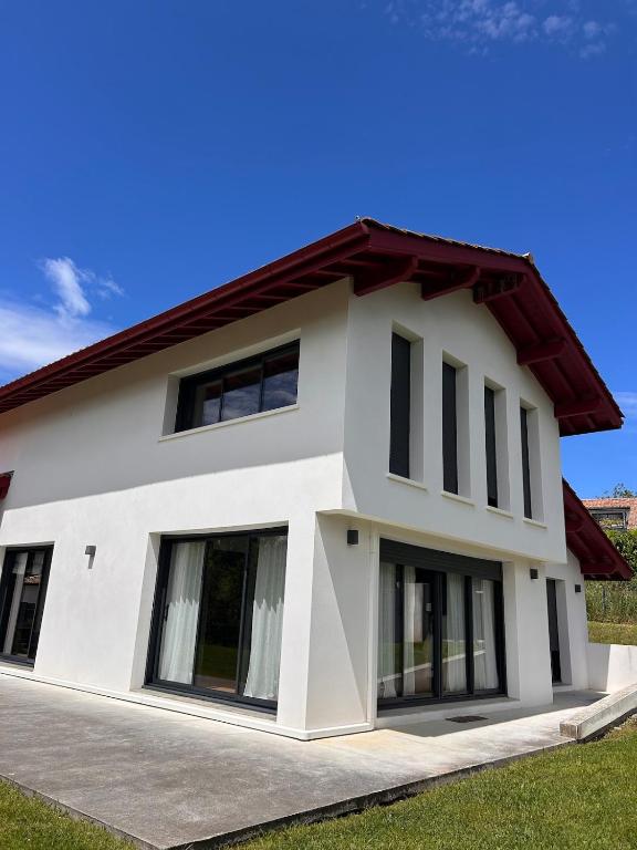 a white house with a red roof at Villa premium avec extérieur ensoleillé in Urrugne