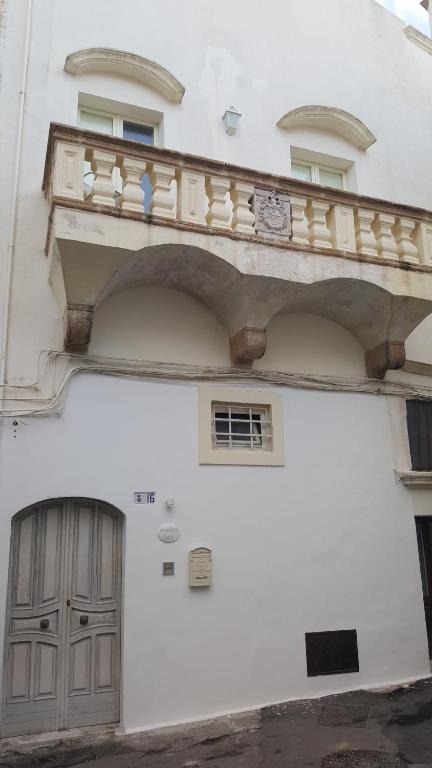 a white building with a balcony and a door at Domus Dejana in Gallipoli
