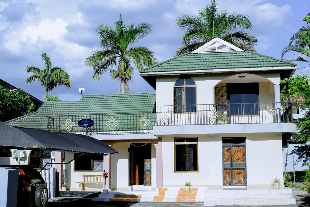 a white house with palm trees in the background at Ziwani House in Mwanza