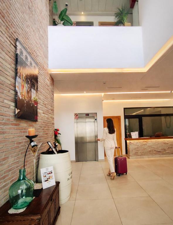 a woman standing in a lobby with her luggage at Hotel Casa Marzo in Cariñena