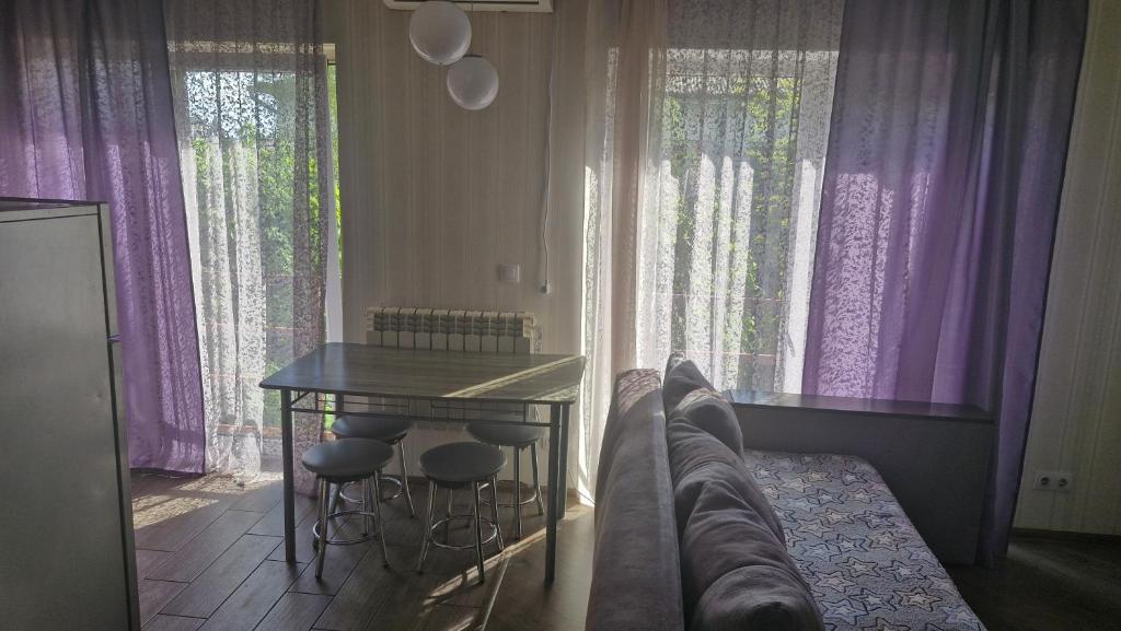 a living room with a table and purple curtains at Старе місто, центр in Lutsk