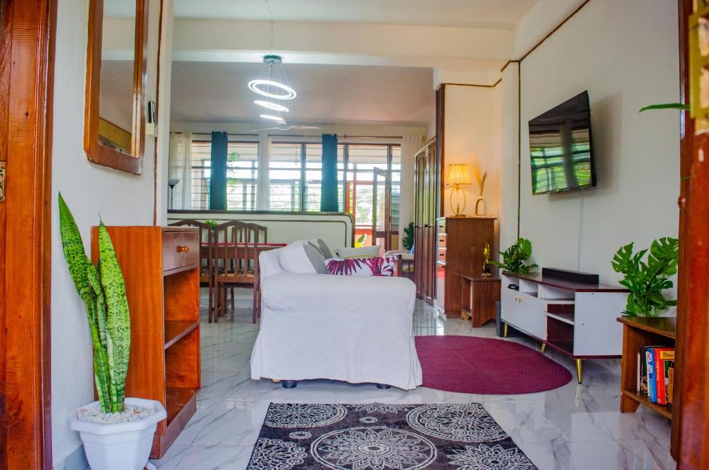a living room with a white couch and a table at Bright Diani Studio with King Bed, 2min to Beach in Diani Beach