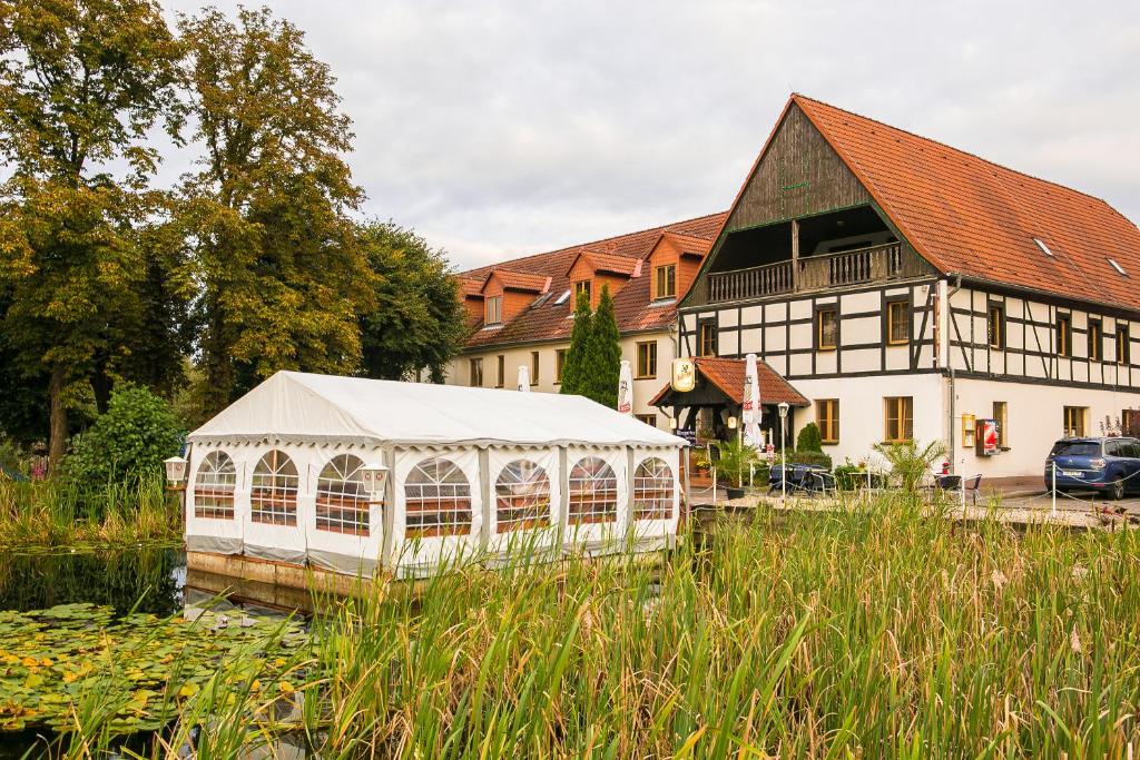 a large white greenhouse in front of a house at Hotel Gröbern am See in Gröbern