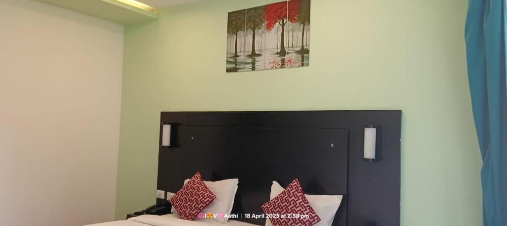 a bedroom with a bed with a black head board at Hotel San Andreas Amar in Kodaikānāl