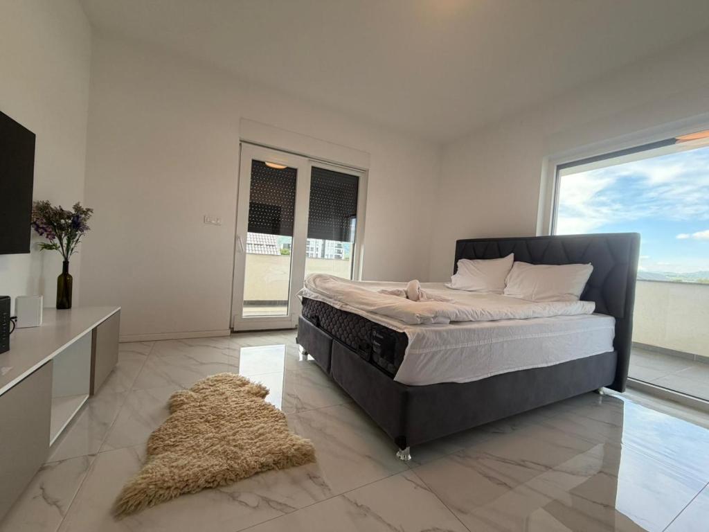 a bedroom with a bed and a television and a rug at Vila Gaia in Sarajevo
