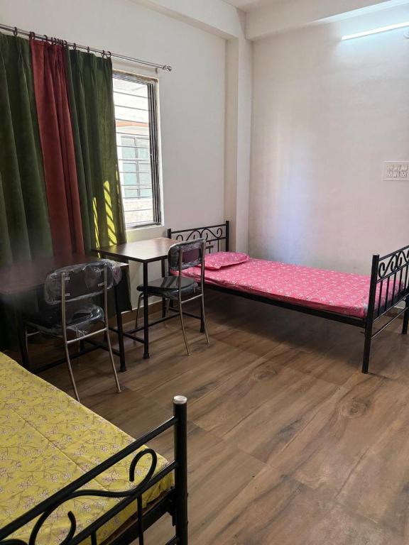 a room with two beds and a table and chairs at Nasa in Panchanai