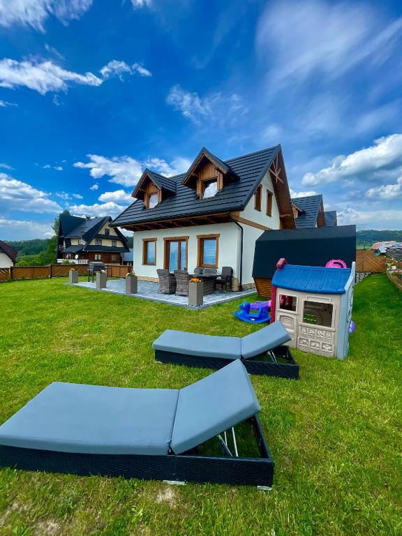 a house with a backyard with picnic tables and a barbecue at Odskocznia2 in Maniowy