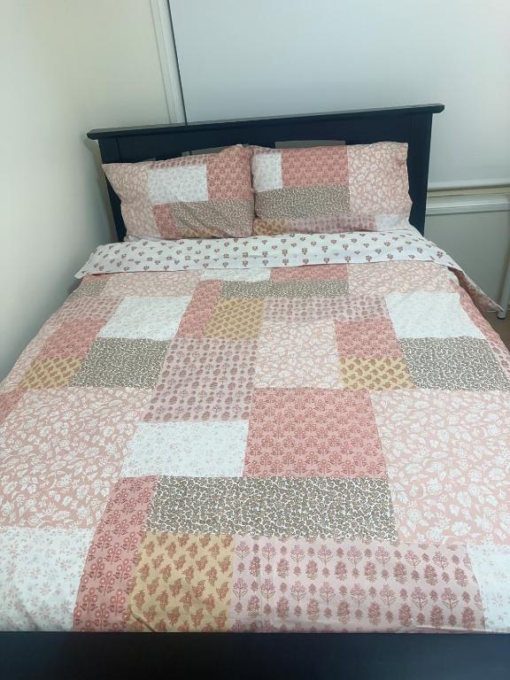a bed with a quilt on top of it at Private Rm6in Elderslie in Elderslie