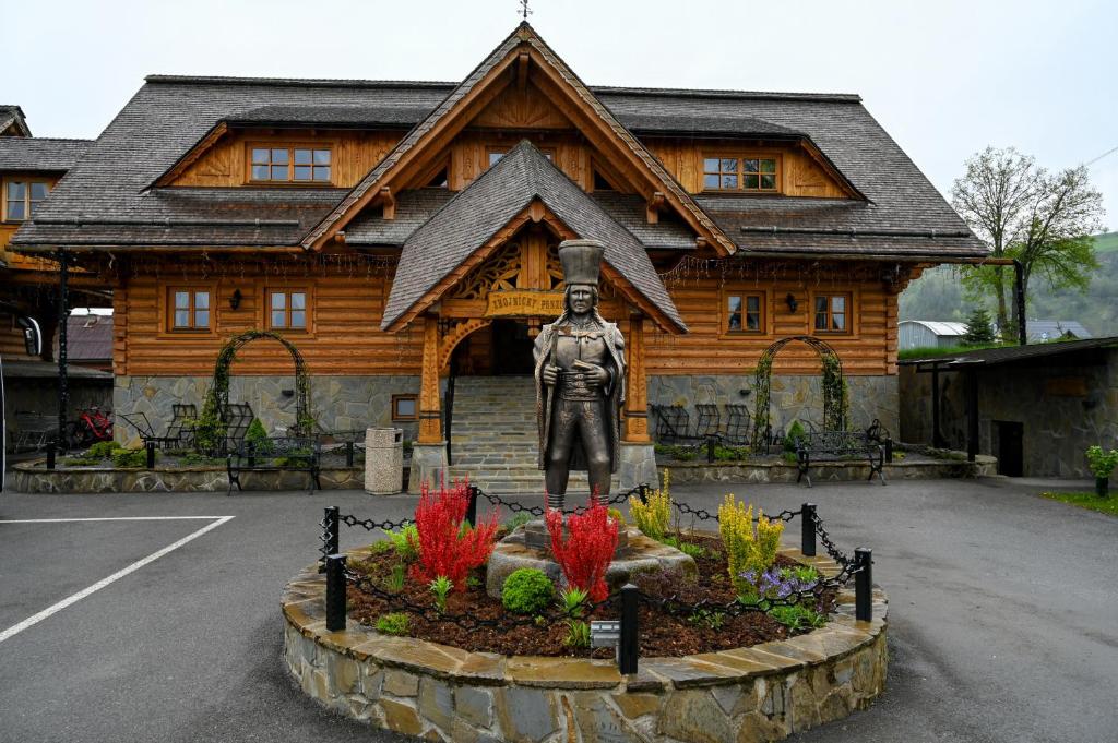 a statue of a man in front of a building at Zbojnicky penzion in Jasenica