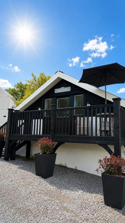 a house with a deck with an umbrella at The Loft in Gwys Station