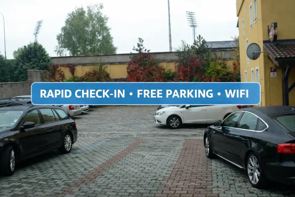 a sign in a parking lot with cars parked at Pension Miltom in České Budějovice