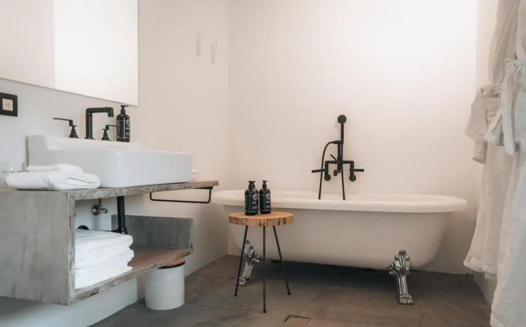 a white bathroom with a tub and a sink at The Grand Indradhar Resort Dharamshala in Dharamshala