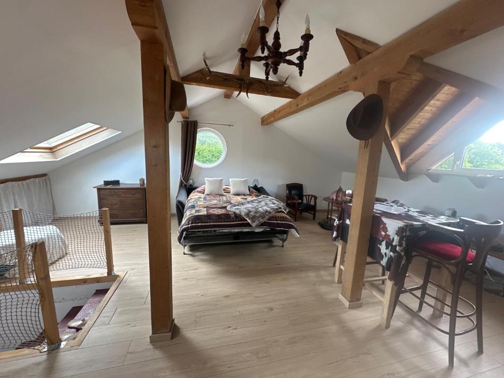 a bedroom with a bed and a table in a room at Chez Clémence & Baptiste in Buhl-Lorraine