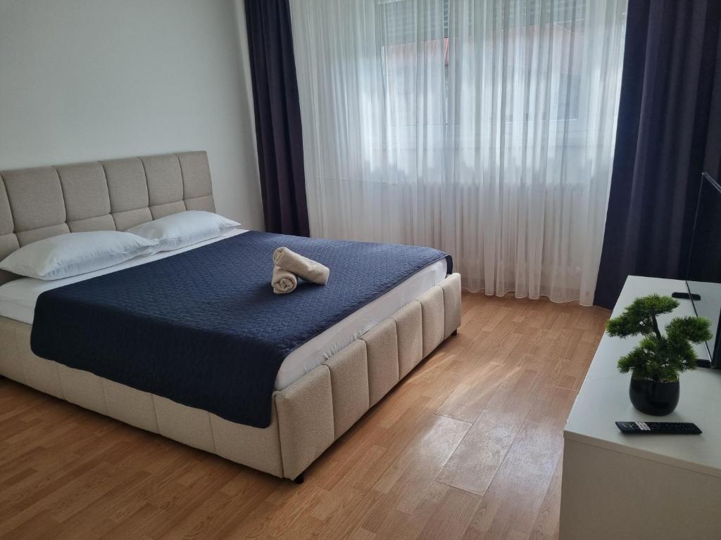 a teddy bear sitting on a bed in a bedroom at Apartman Milica 1 in Doboj