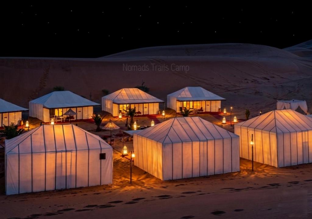 a group of domes in the desert at night at Nomads Trails Camp in Merzouga