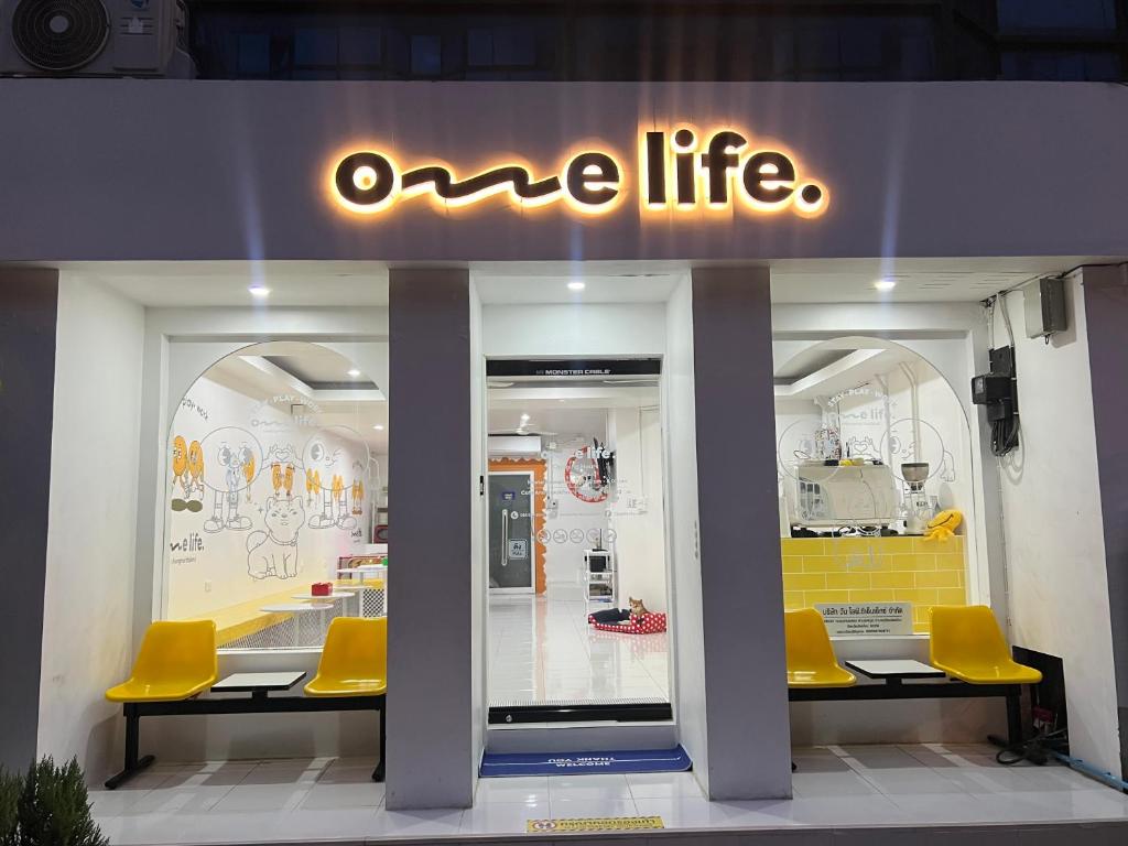 a one life store with yellow chairs in the window at One life Hostel in Chiang Mai