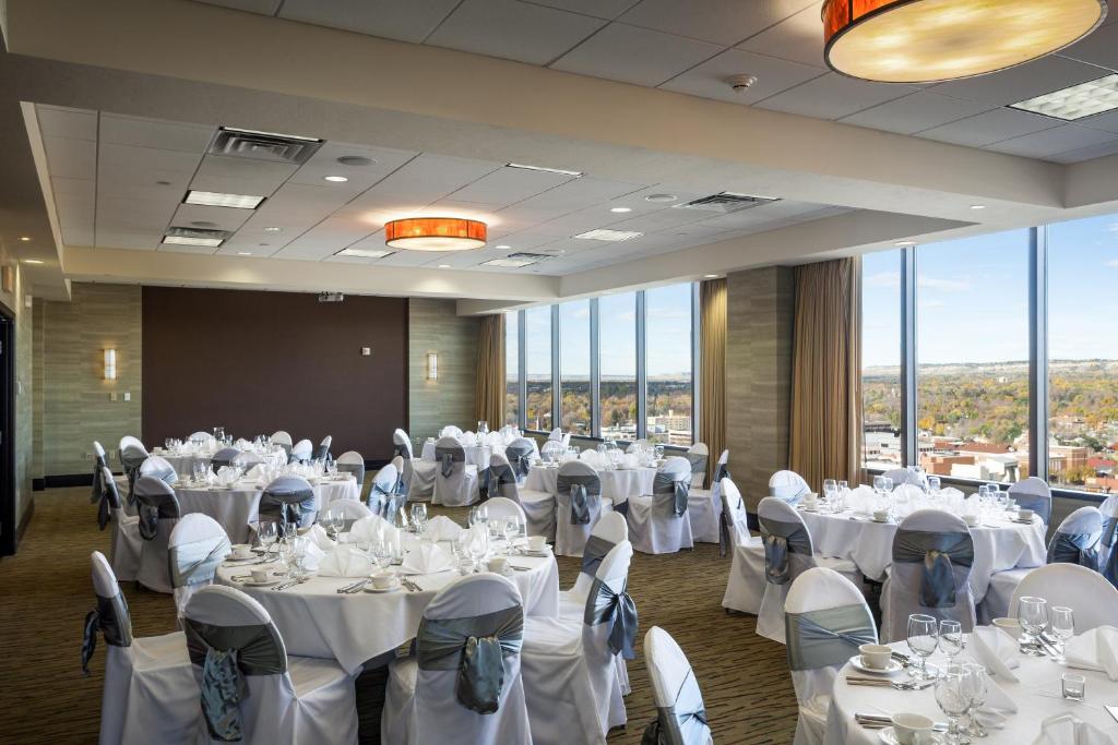 una sala banchetti con tavoli e sedie bianchi e finestre di Doubletree By Hilton Billings a Billings