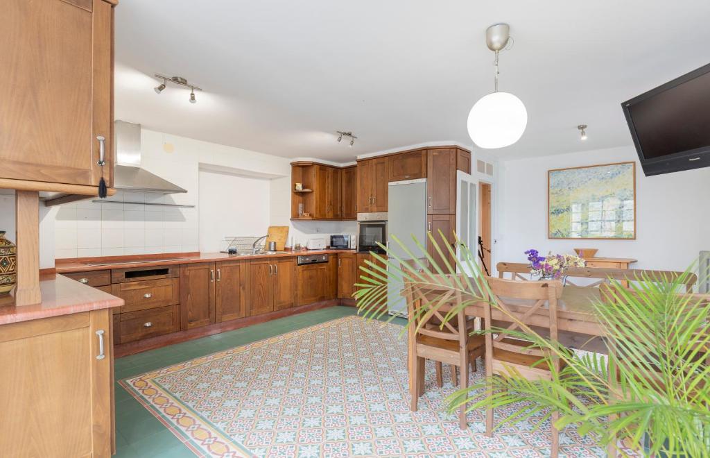 a large kitchen with wooden cabinets and a table at PISO CON TERRAZA in Ribadeo