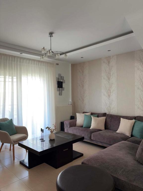 a living room with a couch and a coffee table at Armonia Maisonette in Pefkochori