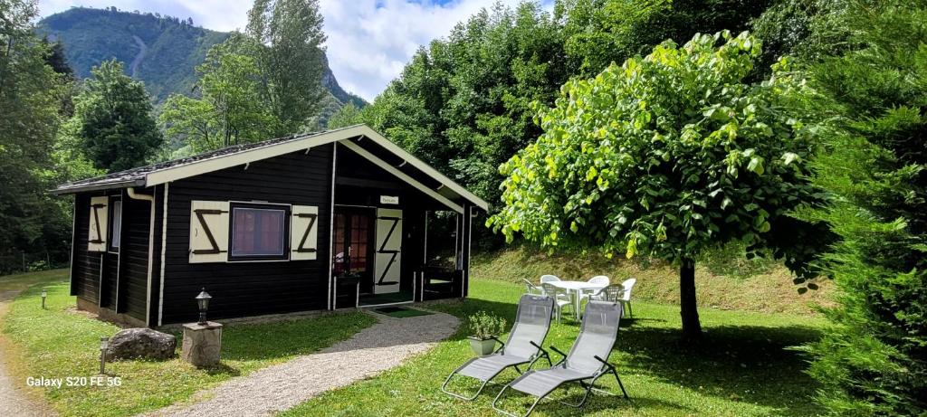 a cabin with a table and chairs in front of it at LES CHALETS de MONTORGUEIL in Saurat