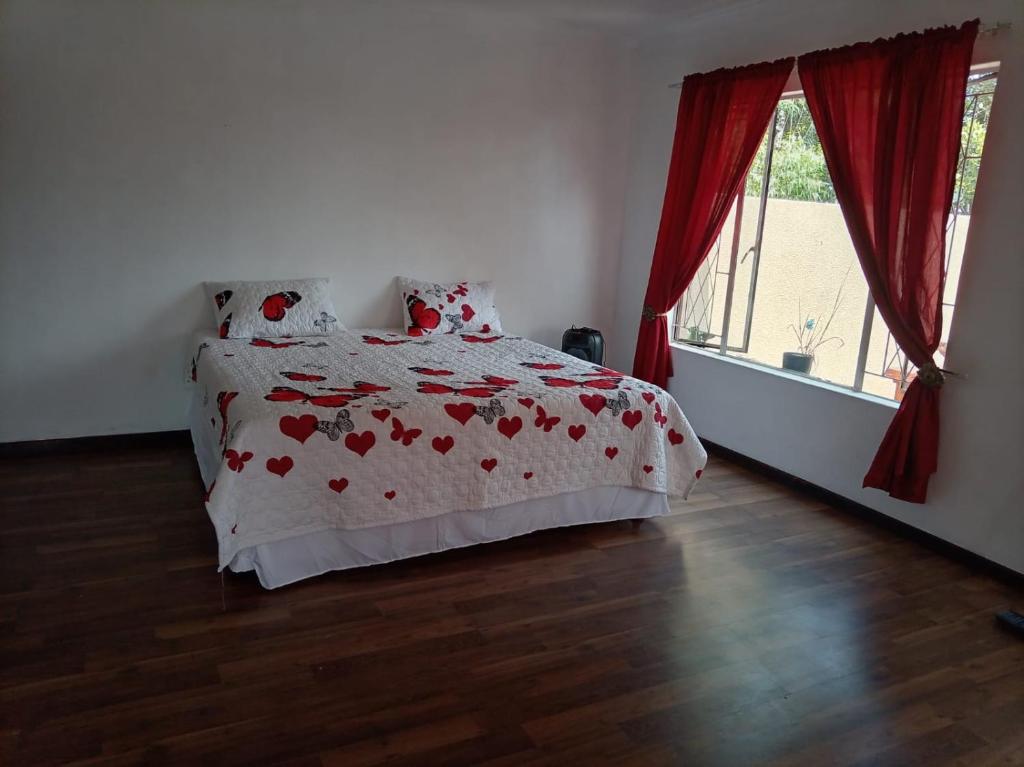 a bedroom with a bed with red hearts on it at Stay with Tayo in Kempton Park