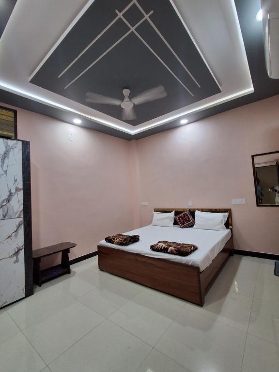 a bedroom with a bed and a ceiling at Hotel Mahamrityunjay Palace in Ujjain