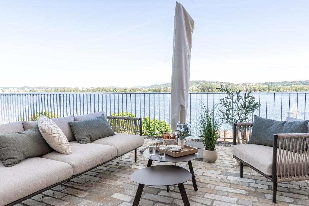 a living room with a couch and a view of the water at Appartements Lago in Tüscherz-Alfermée