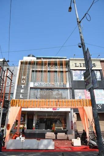 a building with an orange awning in a city at Crown Palace Hotel & Restaurant in Hāpur