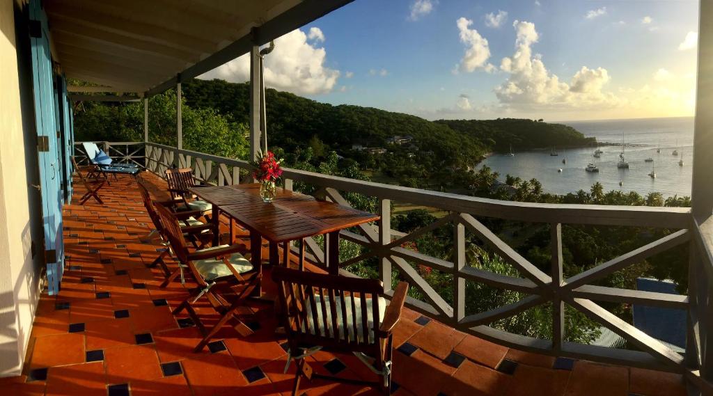 a balcony with a table and chairs and the ocean at Blue Moon Antigua in English Harbour Town