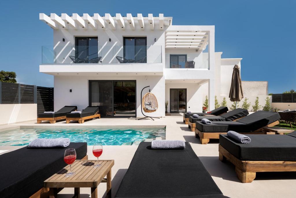 a villa with a swimming pool and black furniture at Villa Dreamscape - Elegant Stay with Private Pool by Villa Mana Gers in Planos
