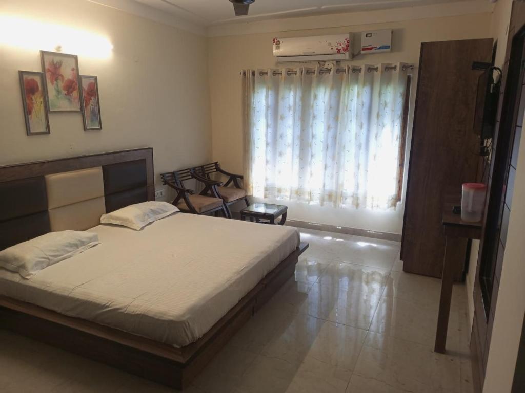 a bedroom with a bed and a large window at Adarsh villa in Dharmsāla