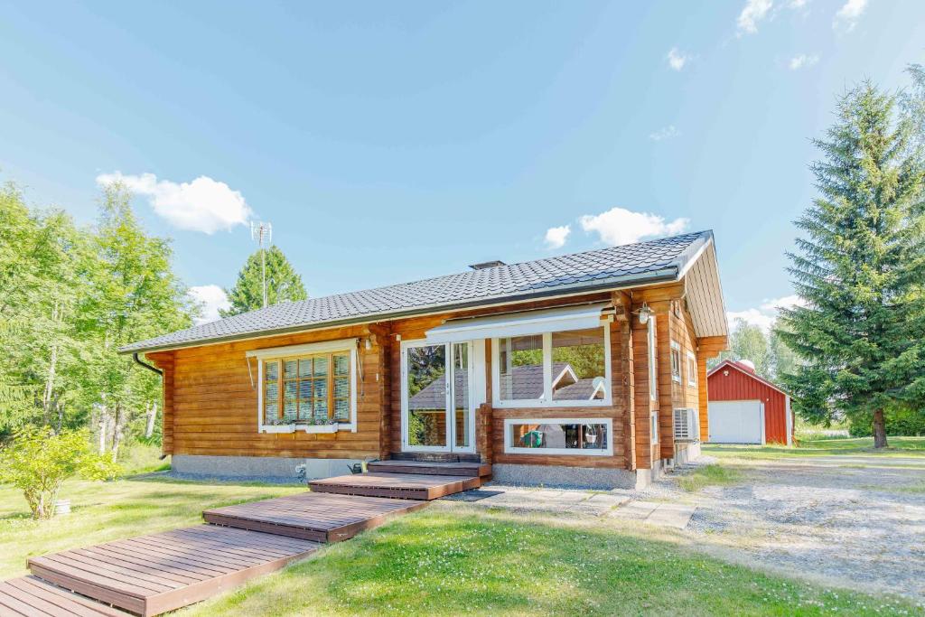 a log home with a deck in the yard at Villa Veneskoski in Veneskoski