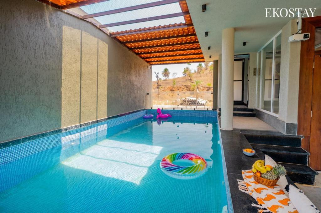 an indoor swimming pool with a pool noodle in a house at EKOSTAY - Casa Elara in Igatpuri