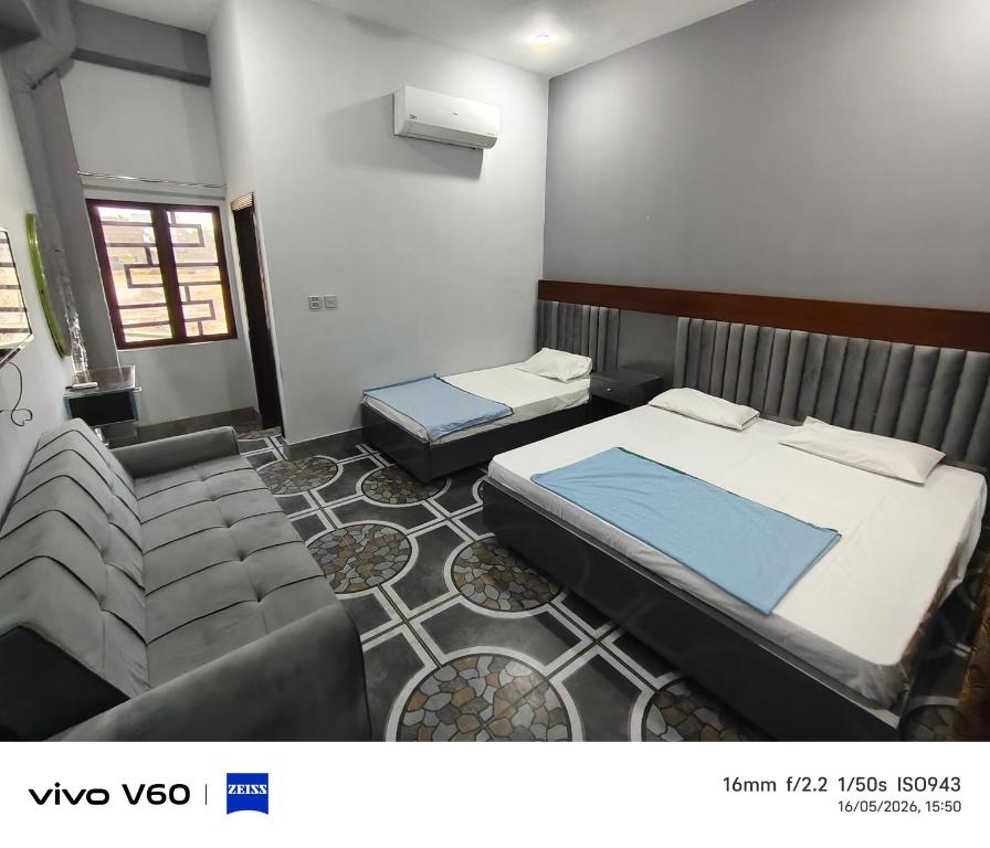 a bedroom with a bed and a couch at Al Qadir Residence in Multan