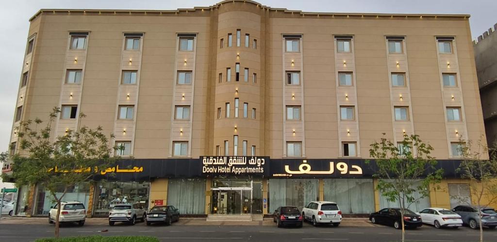 a large building with cars parked in front of it at دولف للشقق الفندقية حي المصيف in Hail
