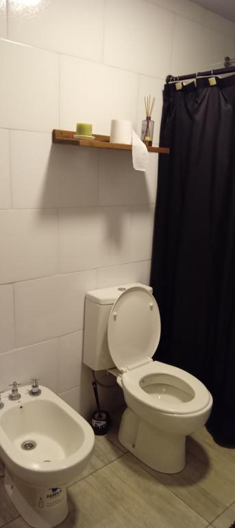 a bathroom with a toilet and a sink at Días y flores in Ranchos