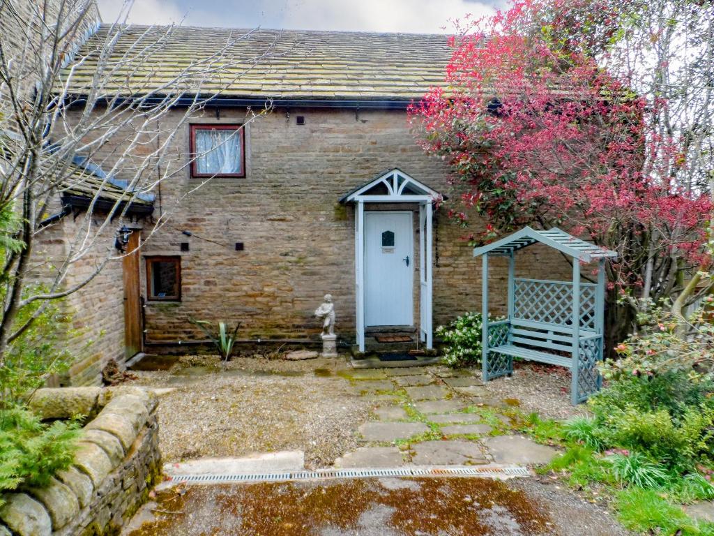 an old brick house with a blue door at Dewsnap Frost - Rb8 in Chinley