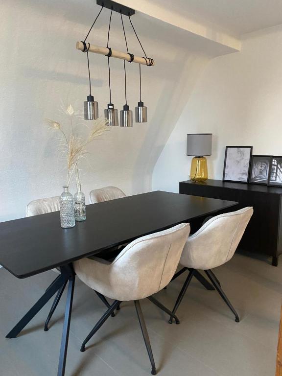 a black dining room table with two white chairs at Moderne 4-Zimmer Wohnung in Wernau
