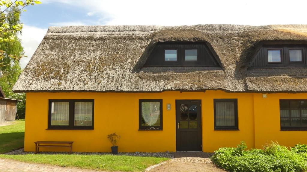 a yellow house with a thatched roof at Ferienwohnung Strandweg 1 in Wieck
