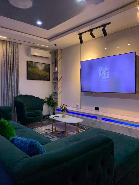 a living room with a couch and a large screen at PrimeNest Apartment in Lekki
