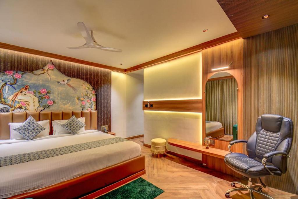 a bedroom with a bed and a desk and a chair at The White Castle Hotel in Mysore