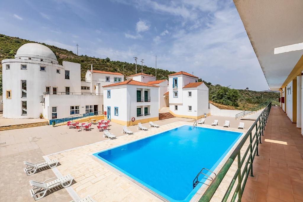 a large swimming pool in front of a house at HI Alcoutim – Pousada de Juventude in Alcoutim