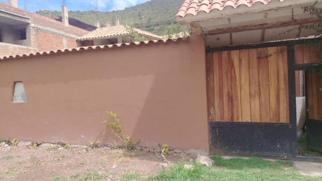 a building with a wooden door in a yard at Intikilla House in Cusco
