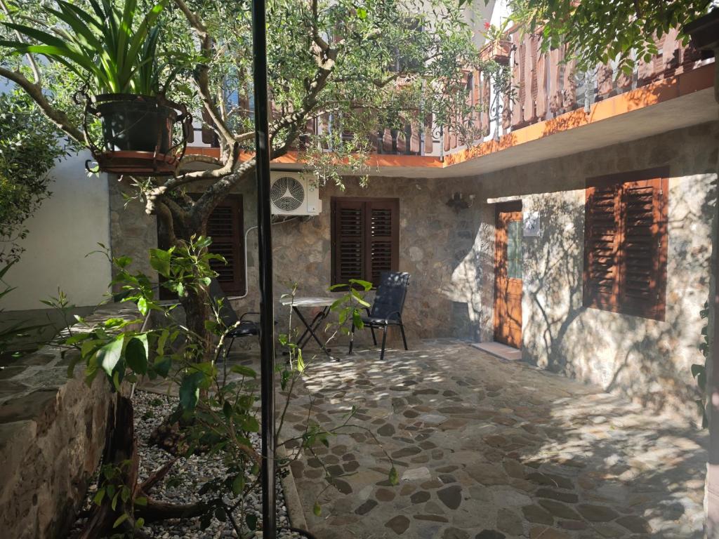 a patio of a house with a chair and a table at Sobe - Rooms NININ in Deskle
